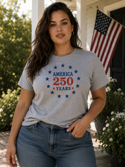 Woman wearing a gray t-shirt with 'America 250' design outdoors.